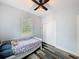 Bedroom features a ceiling fan, a window looking onto trees, wood-look floors and closet at 34335 Berryhill Dr, Webster, FL 33597