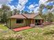 A lovely single story home featuring green stucco and a well-manicured lawn at 34335 Berryhill Dr, Webster, FL 33597