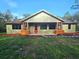 Charming single-story home featuring a welcoming red front door and delightful flower box accents at 34335 Berryhill Dr, Webster, FL 33597