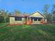 A quaint, single-story home with a warm, inviting red door and pretty flower boxes on the front porch at 34335 Berryhill Dr, Webster, FL 33597