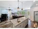 Open-concept kitchen and living room featuring a kitchen island, stainless sink and dark wood-look flooring at 34335 Berryhill Dr, Webster, FL 33597