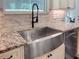 Close up view of kitchen sink with stainless steel appliances, stone countertops, and stylish cabinets at 34335 Berryhill Dr, Webster, FL 33597