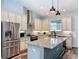 This kitchen offers stainless steel appliances, granite countertops, and an island with a sink and dark wood-look flooring at 34335 Berryhill Dr, Webster, FL 33597