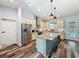 Well-lit kitchen features granite countertops, a center island, stainless steel appliances and stylish wood-look floors at 34335 Berryhill Dr, Webster, FL 33597