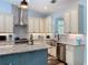Bright kitchen offers granite countertops, stainless steel appliances and fixtures, an island and light blue walls at 34335 Berryhill Dr, Webster, FL 33597