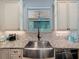 Charming kitchen featuring a farmhouse sink, granite countertops, and ample cabinet space at 34335 Berryhill Dr, Webster, FL 33597