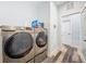 Bright laundry room with stacked washer and dryer and wood-look tiled floor at 34335 Berryhill Dr, Webster, FL 33597