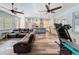 Open living space featuring a leather sectional sofa, modern ceiling fan, and hardwood style floors adjacent to the kitchen at 34335 Berryhill Dr, Webster, FL 33597
