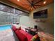 Cozy outdoor living area with comfortable seating, ceiling fan, and view of the pool at 34335 Berryhill Dr, Webster, FL 33597