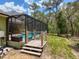 Charming screened-in pool and deck overlooking a lush yard, blending indoor and outdoor living at 34335 Berryhill Dr, Webster, FL 33597
