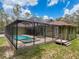 Wide view of the screened-in pool and patio area, perfect for enjoying sunny days at 34335 Berryhill Dr, Webster, FL 33597