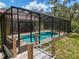 Beautiful screened-in pool with spa, accessible by a wooden deck and steps at 34335 Berryhill Dr, Webster, FL 33597