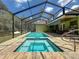 Sparkling screened-in pool and spa area with an open view, ready for summer fun at 34335 Berryhill Dr, Webster, FL 33597