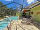 Beautiful screened-in pool and hot tub with an outdoor kitchen and lounge chairs at 34335 Berryhill Dr, Webster, FL 33597