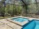 Beautiful screened-in spa and pool combination with lush greenery, offering a private retreat at 34335 Berryhill Dr, Webster, FL 33597