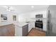 Open kitchen showcases stainless steel appliances, island with sink, and wood flooring at 3554 Arrowhead Ave, Spring Hill, FL 34606