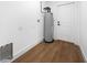Utility room features wood floors and a water heater for on-demand hot water at 3554 Arrowhead Ave, Spring Hill, FL 34606
