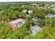 Aerial view showcases tennis courts and a basketball court surrounded by trees in a residential community at 3900 Autumn Amber Dr, Spring Hill, FL 34609