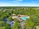 Aerial view of a fun community pool with splash pad and slide surrounded by lush trees at 3900 Autumn Amber Dr, Spring Hill, FL 34609