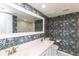 Stylish bathroom with a double vanity and floral wallpaper, creating a fresh aesthetic at 4008 Passport Ln # 104, New Port Richey, FL 34653