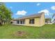 Bright yellow home featuring a screened-in lanai and lush green backyard at 4125 Mc Clung Dr, New Port Richey, FL 34653
