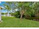Lush backyard view overlooking a serene pond with a fountain feature and mature trees at 4125 Mc Clung Dr, New Port Richey, FL 34653