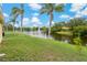 Lush backyard featuring a pond with fountain views and mature palm trees at 4125 Mc Clung Dr, New Port Richey, FL 34653