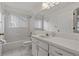 Bright bathroom featuring a tub and shower, all-white fixtures, and a large mirror at 4125 Mc Clung Dr, New Port Richey, FL 34653