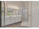 Bathroom featuring a double vanity, large mirror, glass shower, and decorative wallpaper at 4125 Mc Clung Dr, New Port Richey, FL 34653