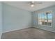 Light blue bedroom with a ceiling fan, a window, and neutral carpet at 4125 Mc Clung Dr, New Port Richey, FL 34653