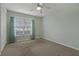 Cozy bedroom with a ceiling fan, carpeted floor, and window with blinds and curtains at 4125 Mc Clung Dr, New Port Richey, FL 34653