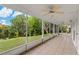 Enclosed lanai with tile floor offering scenic views of the lake and backyard at 4125 Mc Clung Dr, New Port Richey, FL 34653