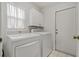 Functional laundry room with washer, dryer, white cabinets, and a tile floor at 4125 Mc Clung Dr, New Port Richey, FL 34653