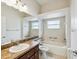 Bright bathroom featuring a shower over tub and large mirror at 4266 High Ridge Ave, Spring Hill, FL 34609