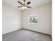 Neutral bedroom with carpet floors, a ceiling fan and a window overlooking the neighborhood at 4266 High Ridge Ave, Spring Hill, FL 34609