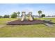 Community playground with multiple slides and climbing structures surrounded by green space and palm trees at 4266 High Ridge Ave, Spring Hill, FL 34609