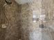 Detailed view of the tiled shower featuring a mounted shower head and built-in shelving at 4266 High Ridge Ave, Spring Hill, FL 34609