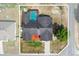Aerial view of the house with a screened pool, and a large backyard with a fire pit at 4289 Castle Ave, Spring Hill, FL 34609