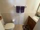 Compact bathroom featuring toilet, vanity with sink and a tiled half wall at 4289 Castle Ave, Spring Hill, FL 34609