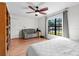 Bedroom featuring a large window, ceiling fan, hardwood floor, and a cozy couch at 4289 Castle Ave, Spring Hill, FL 34609