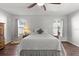 Cozy bedroom with a patterned bedspread, hardwood floors, and a ceiling fan at 4289 Castle Ave, Spring Hill, FL 34609