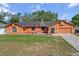 Charming single-story home with an orange exterior, brick driveway, and a well-maintained front lawn at 4289 Castle Ave, Spring Hill, FL 34609