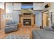 Cozy living room with brick fireplace and mantle, TV, and hardwood floors at 4289 Castle Ave, Spring Hill, FL 34609