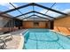 Refreshing private pool in a screened enclosure, with brick pavers and outdoor seating at 4289 Castle Ave, Spring Hill, FL 34609