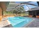 Sparkling private pool in a screened enclosure, surrounded by brick pavers and lounge chairs at 4289 Castle Ave, Spring Hill, FL 34609