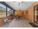 Enclosed sunroom featuring tile flooring, multiple windows, and patio furniture at 4289 Castle Ave, Spring Hill, FL 34609