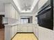 Well-lit kitchen with white cabinets, stainless steel appliances and view into adjacent room at 4388 Craftsbury Dr, New Port Richey, FL 34652