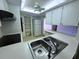 Functional kitchen with stainless steel sink, white cabinets, and modern appliances at 4388 Craftsbury Dr, New Port Richey, FL 34652