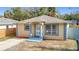 Charming single-story home featuring a blue and yellow color scheme and a well-manicured front lawn at 4503 Courtland St, Tampa, FL 33610