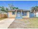 Charming single-story home featuring a blue and yellow color scheme and a well-manicured front lawn at 4503 Courtland St, Tampa, FL 33610